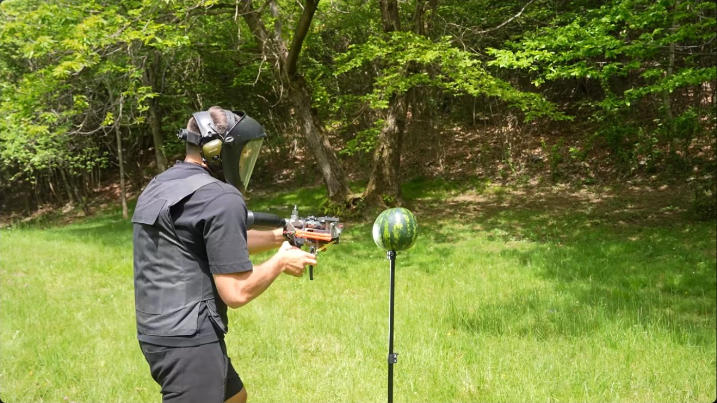 Test target positioning showing a watermelon mounted at approximately one meter standoff from the cannon muzzle, the distance at which volume begins to significantly affect destructive range.