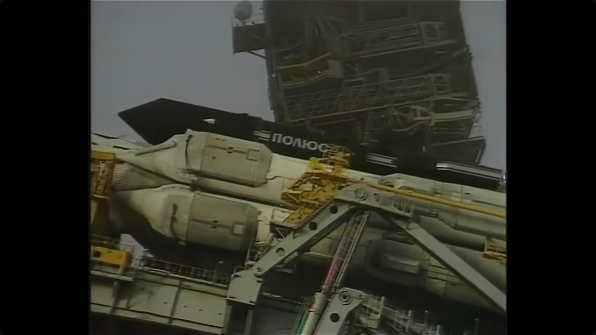 Archival footage of a Buran orbiter being transported horizontally, stacked atop the Atlant carrier aircraft. The modified bomber could barely make it off the runway but flew 150 missions to ferry components.